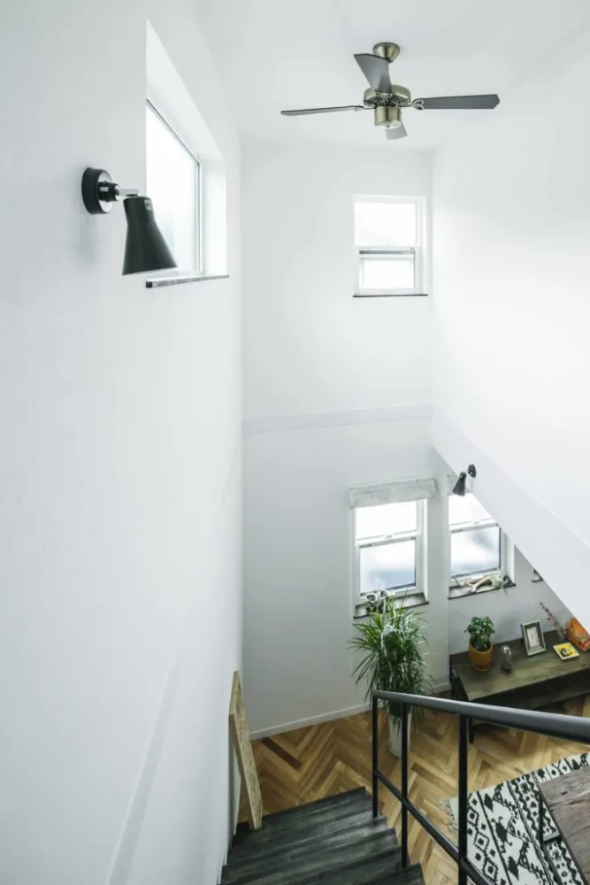 吹き抜けから光が溢れる、白と木目が調和した北欧モダンな家