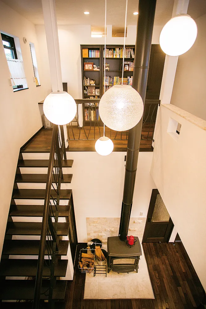 薪ストーブが主役の吹き抜け空間。家族の気配を縦に繋ぐ、開放感あふれる家